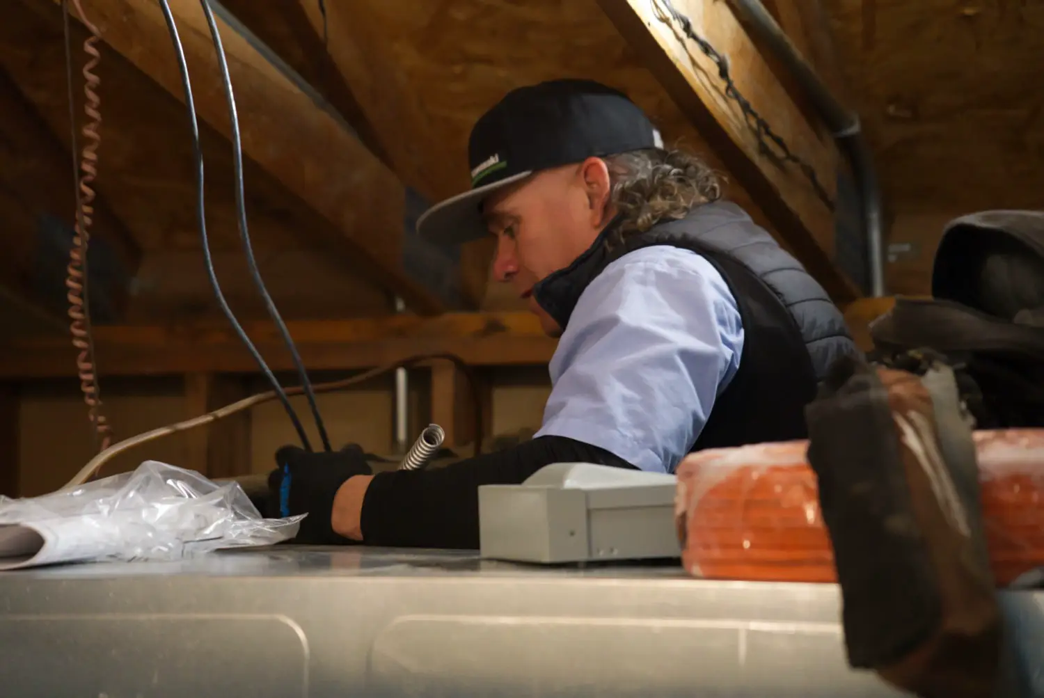 Nalk technician working on HVAC equipment in an attic